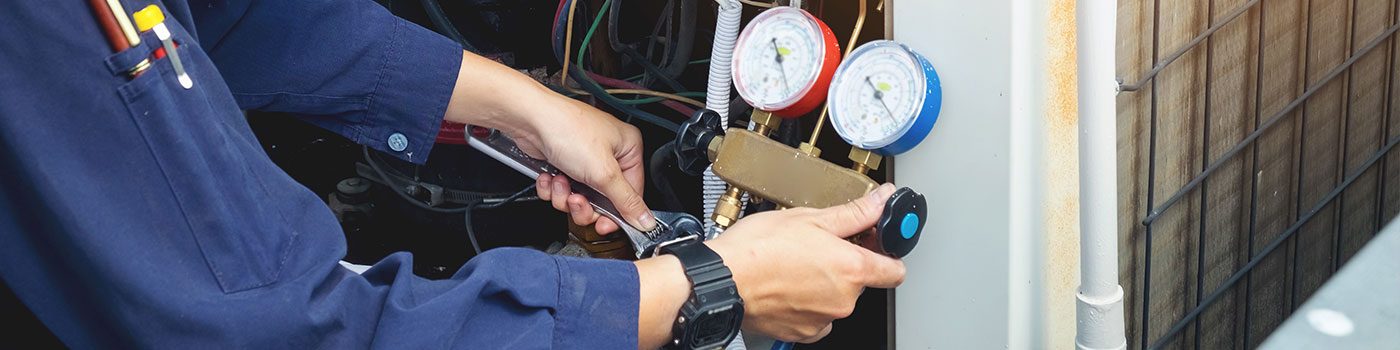 Technicien contrôlant un circuit de climatisation avec un manomètre